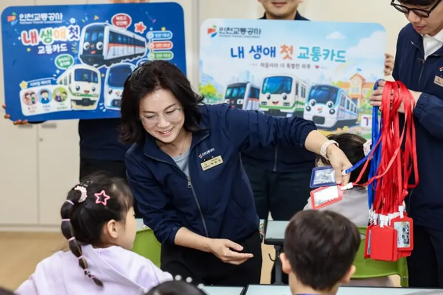 어린이들에게 캐릭터 선불 교통카드와 목걸이형 카드케이스를 전달하는 백보옥 인천교통공사 영업본부장